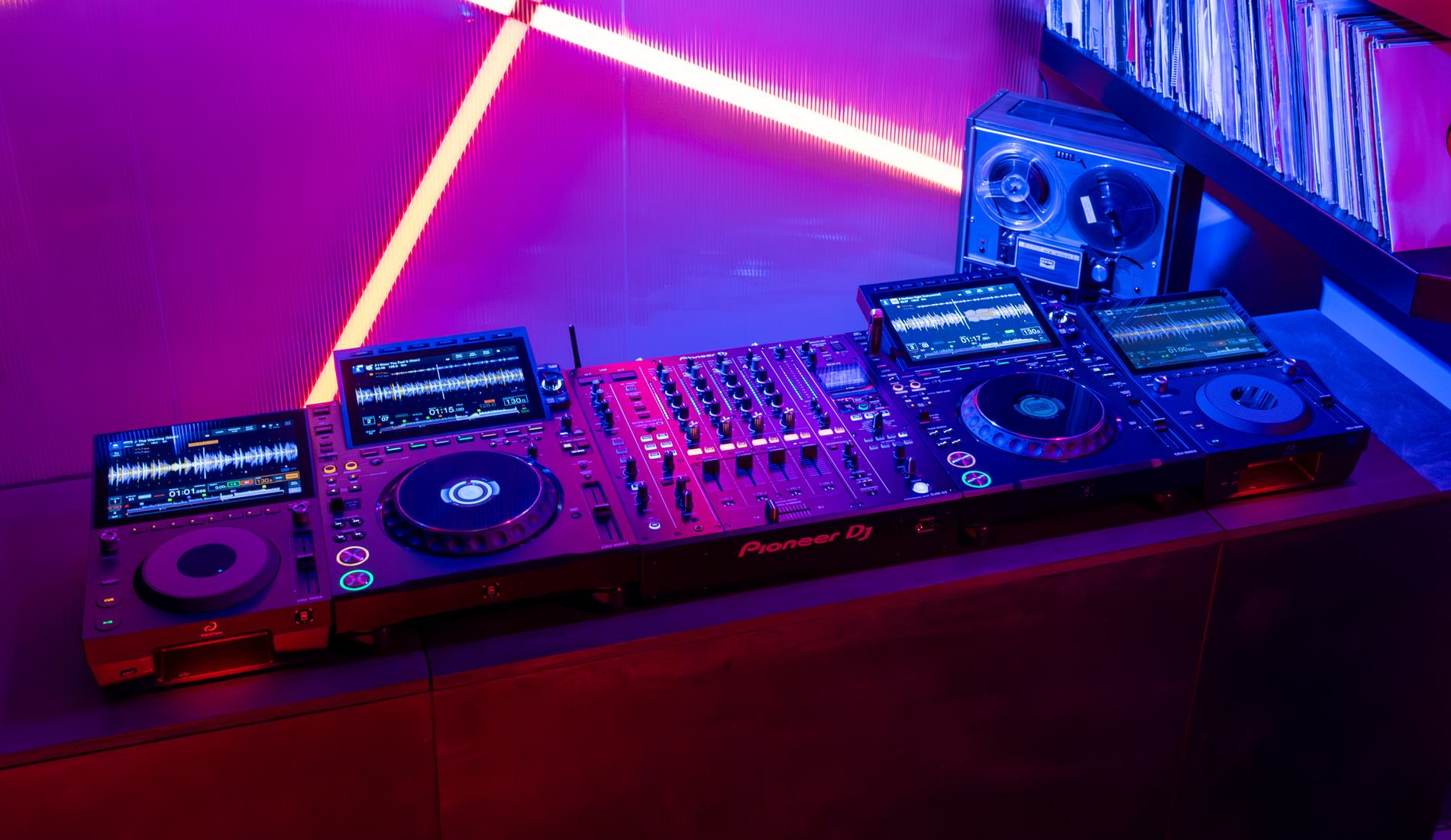 DJ playing on an AlphaTheta system next to a laptop
