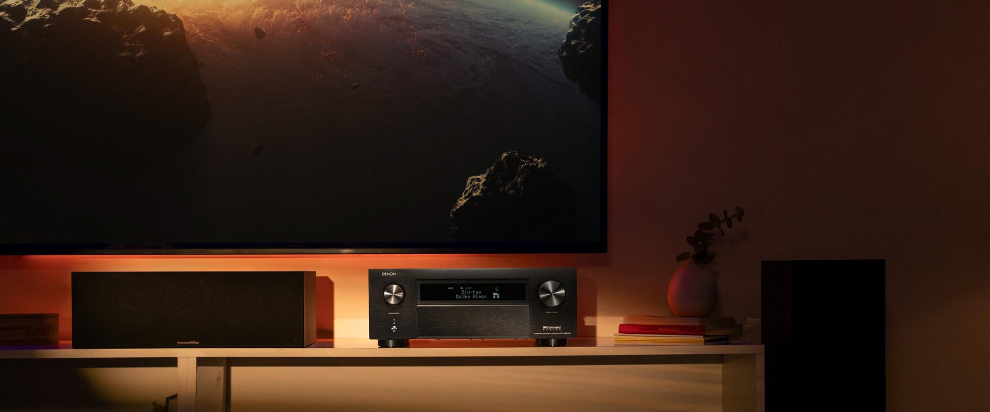 Denon AV receiver and home theater system lit by the glow of a film